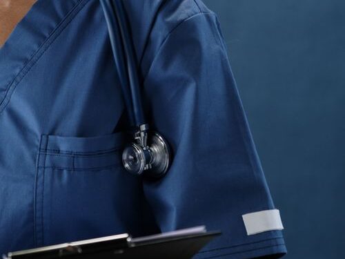 Stéthoscope posé sur l'épaule d'un professionnel de santé en blouse